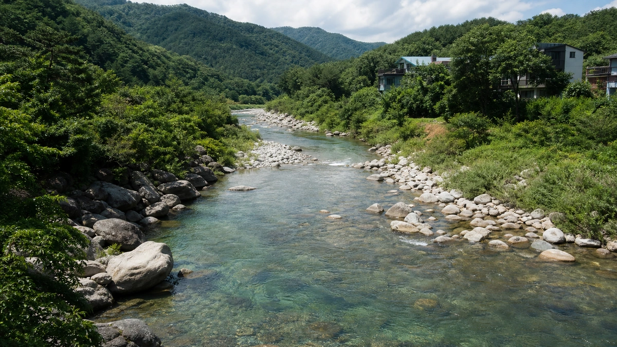 가평 대성리 구운천의 둥근 하상석과 낮은 산지, MT촌 건물이 보이는 여름 전경