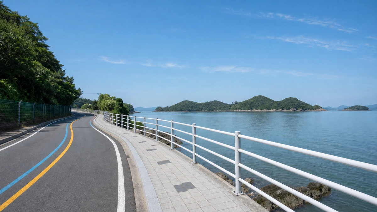 사천만을 끼고 굽어지는 실안 해안도로와 흰색 난간의 보행 가장자리