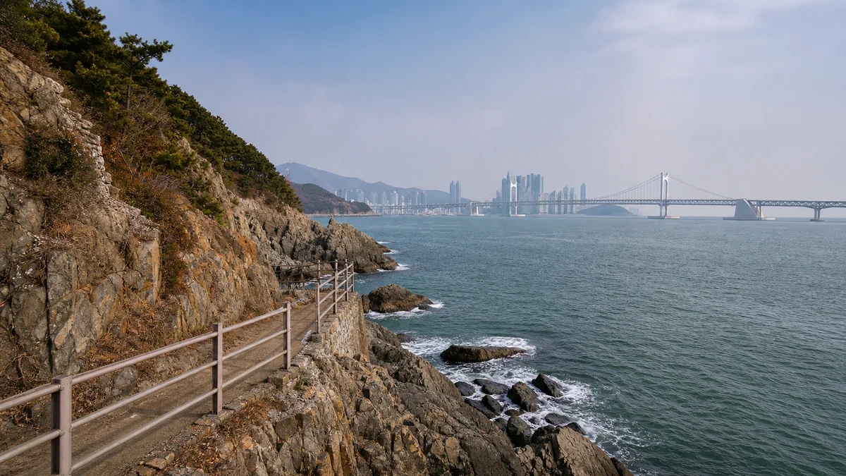 부산 송도 해안의 붉은 난간 데크와 계단, 바위 절벽 옆으로 이어지는 이동 공간과 남항대교 조망