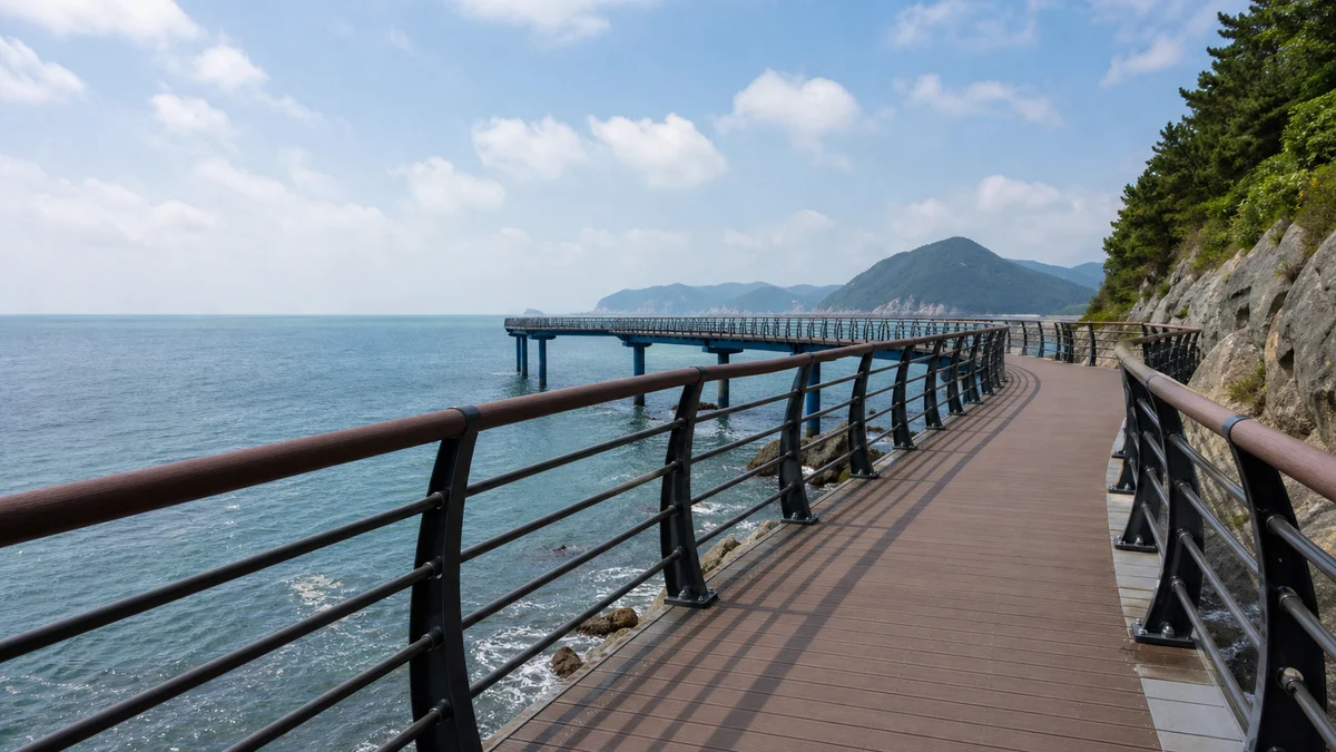 부산 송도구름산책로의 바다 위 데크와 난간, 해안 바위와 맞은편 섬이 보이는 산책 장면