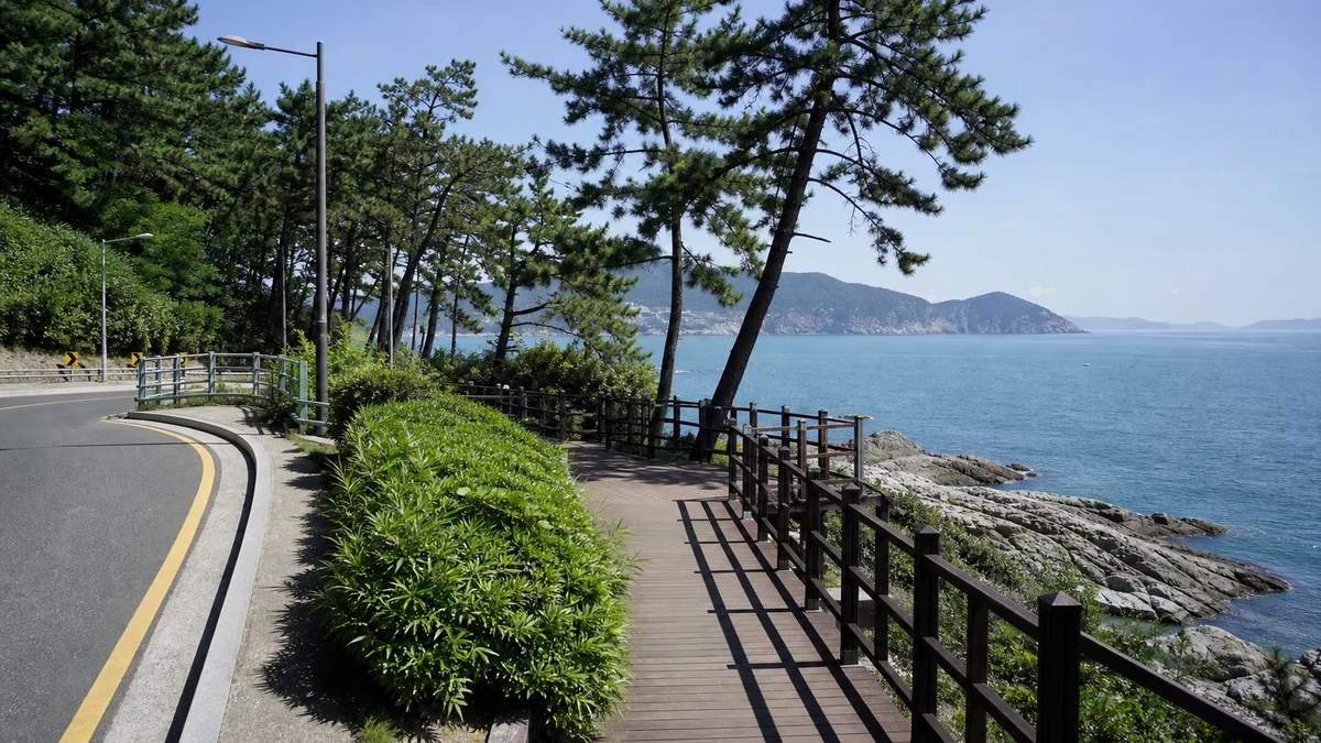 부산 송도구름산책로의 바다 위 데크와 난간, 해안 바위와 맞은편 섬이 보이는 산책 장면