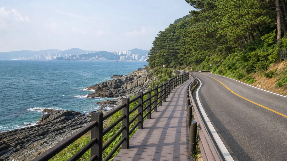 부산 송도해수욕장에 주황빛 저녁 햇살이 내려앉고 잔잔한 물결이 모래사장에 닿는 시간대 장면