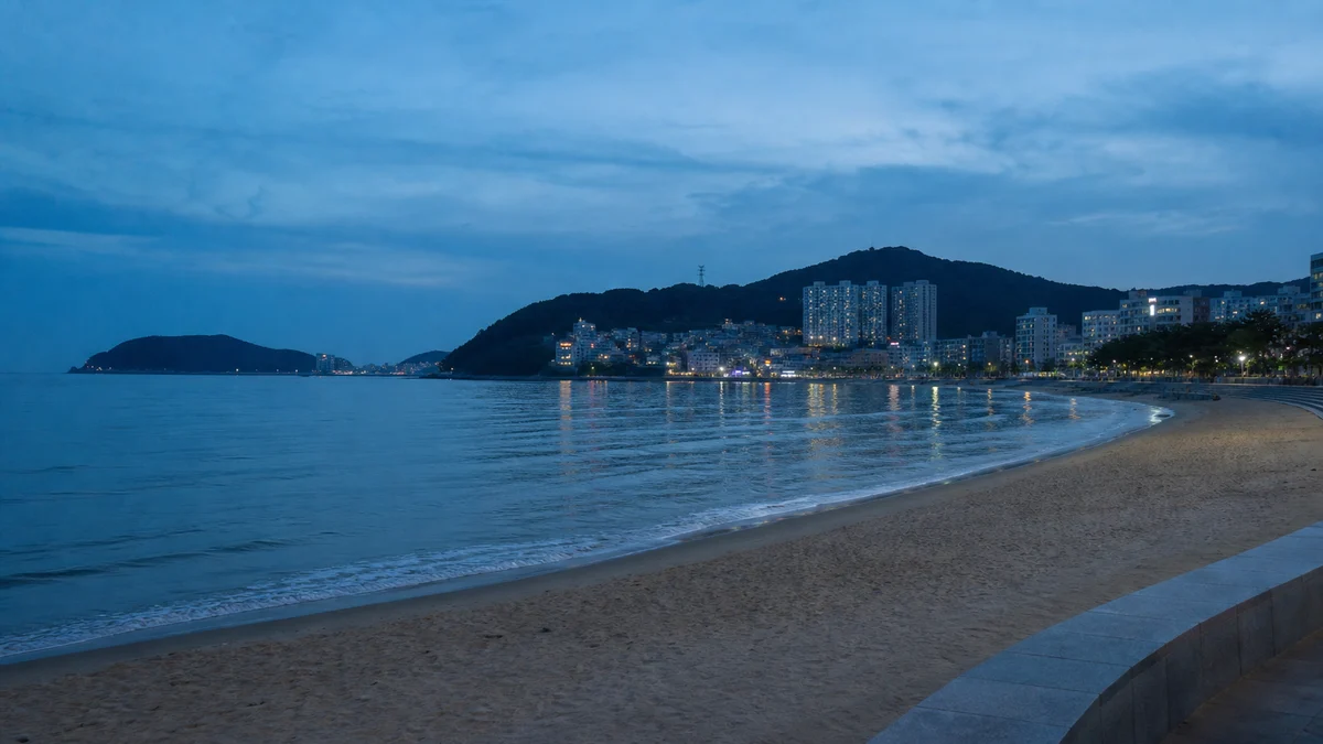 송도해수욕장 산책로와 수면에 도심 불빛이 비치는 청색시간 풍경